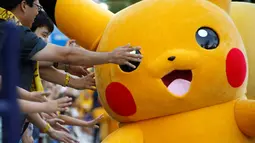 Warga bersuka cita menunggu parade Pikachu dalam serial animasi Pokemon melakukan parade di Yokohama , Jepang , 7 Agustus 2016. (REUTERS / Kim Kyung - Hoon)