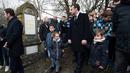 Presiden Prancis Emmanuel Macron berjalan melewati makam Yahudi yang dicoret simbol Nazi di pemakaman Yahudi, Quatzenheim, Prancis, Selasa (19/2). Macron menyempatkan diri untuk memeriksa kerusakan yang ditimbulkan. (Frederick FLORIN/AFP)