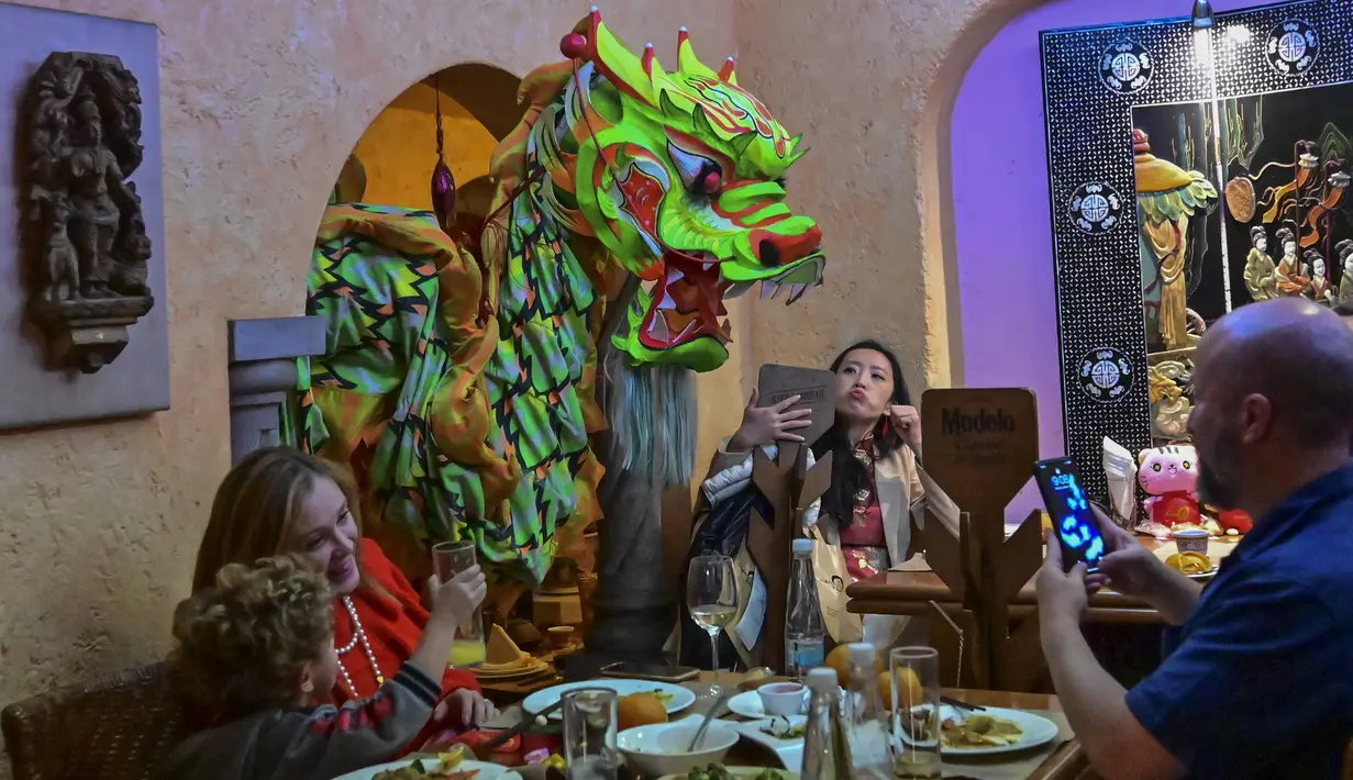 Anggota komunitas Tionghoa di Meksiko menampilkan tarian naga tradisional (liong) di sebuah restoran Tiongkok menyambut Tahun Baru Imlek di Mexico City, pada 31 Januari 2022. Tahun Baru Imlek 2022 menandai dimulainya tahun Shio Macan Air. (PEDRO PARDO / AFP)