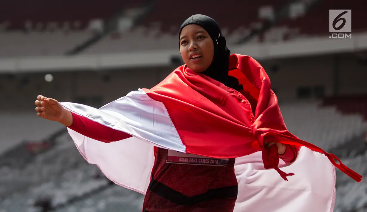 Pelari Indonesia, Tiarani Karisma Evi melakukan selebrasi usai meraih medali emas Asian Para Games cabang atletik nomor lari 100 meter T42 / T63 di SUGBK, Jakarta, Rabu (10/10). Evi mencatatkan waktu 14,98 detik. (Bola.com/Vitalis Yogi Trisna)