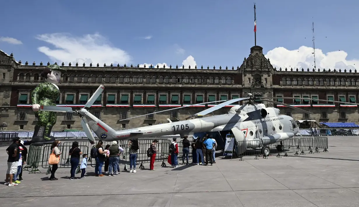 Orang-orang mengantre untuk masuk ke helikopter MI-17 Angkatan Udara Meksiko dalam pameran yang disebut The Great Force of Mexico di Alun-Alun Zocalo, Mexico City, Meksiko, 20 September 2021. (ALFREDO ESTRELLA/AFP)