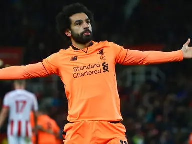 Gelandang Liverpool, Mohamed Salah berselebrasi setelah berhasil mencetak gol ke gawang Stoke City pada pekan ke-14 Premier League di Bet365 Stadium, Kamis (30/11). Dua gol Salah sukses mencukur Stoke City 3-0. (Geoff CADDICK/AFP)