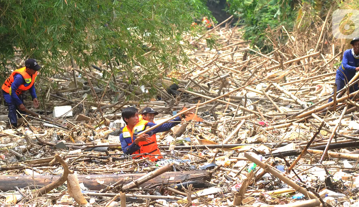 Petugas gabungan membersihkan tumpukan sampah yang menyumbat aliran air Sungai Cikeas di kawasan Bendung Koja Jatiasih, Bekasi, Jawa Barat, Rabu (16/10/2019). Pembersihan sekitar 1.200 meter kubik sampah bambu tersebut diperkirakan menghabiskan waktu dua minggu. (merdeka.com/Arie Basuki)