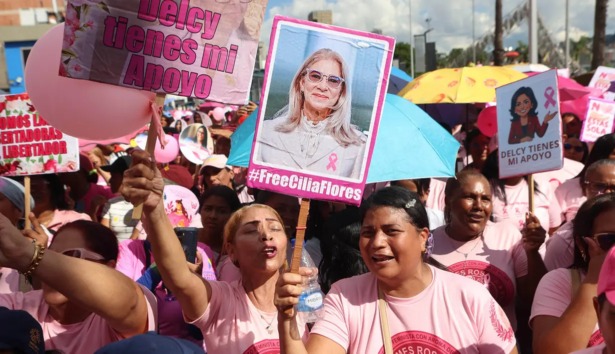 Seorang perempuan memegang poster bergambar mantan Ibu Negara Venezuela, Cilia Flores, saat mengikuti pawai yang diselenggarakan pemerintah untuk meningkatkan kesadaran terhadap kanker payudara dalam rangka Bulan Peduli Kanker Payudara atau Pink Month di Caracas, Venezuela, Kamis (22/10/2026). (AP Photo/Pedro Mattey)