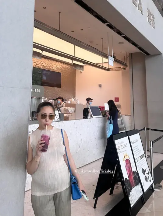 Nikita Willy mengenakan setelan pleated sleeveless top dan pants berwarna krem serta tas biru. [@nonawilly16]