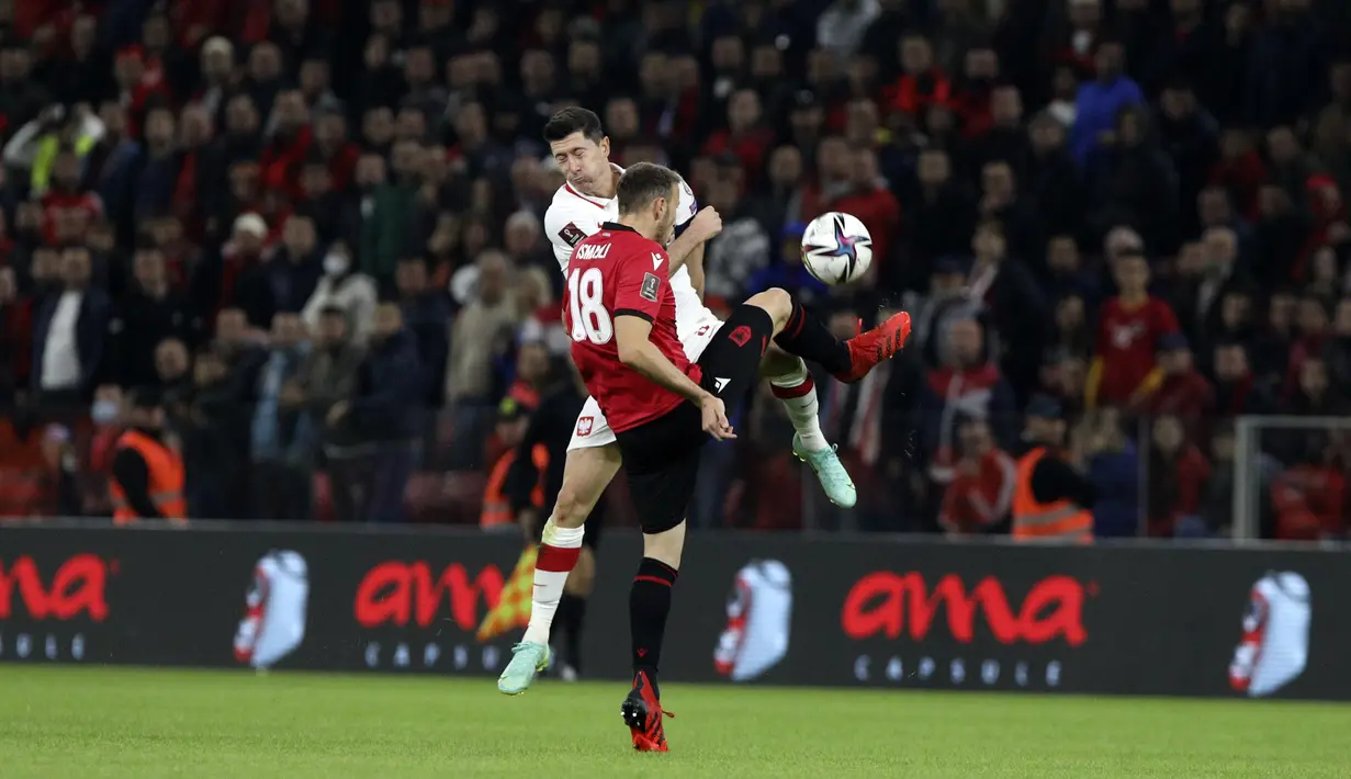 Penyerang Polandia Robert Lewandowski dan bek Albania Ardian Ismajli berebut bola pada lanjutan Kualifikasi Piala Dunia 2022, di Air Albania Stadium, Rabu (13/10/2021) dini hari WIB. Kemenangan Polandia 1-0 atas Albania diwarnai aksi pelemparan botol oleh suporter. (AP Photo/Franc Zhurda)