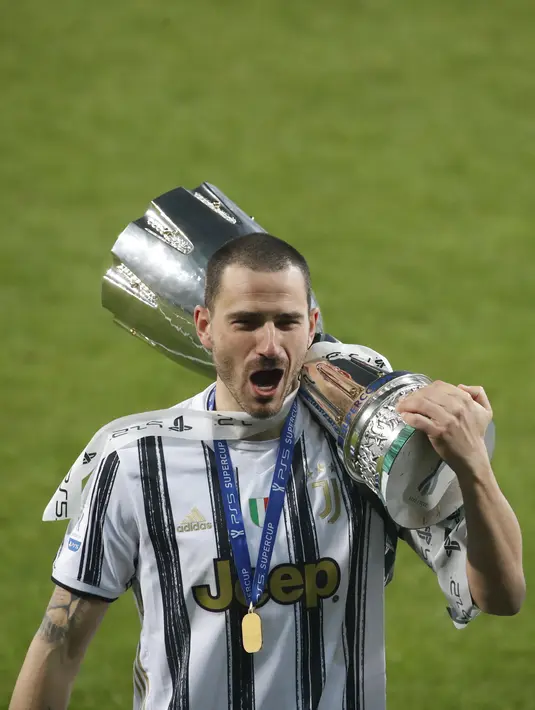 Bek Juventus, Leonardo Bonucci membawa Piala Super Italia usai mengalahkan Napoli di Stadion Mapei di Reggio Emilia, Italia, Kamis (21/1/2021). Juventus kini tercatat sebagai tim yang paling sering menjuarai Piala Super Italia. (AP Photo/Antonio Calanni)