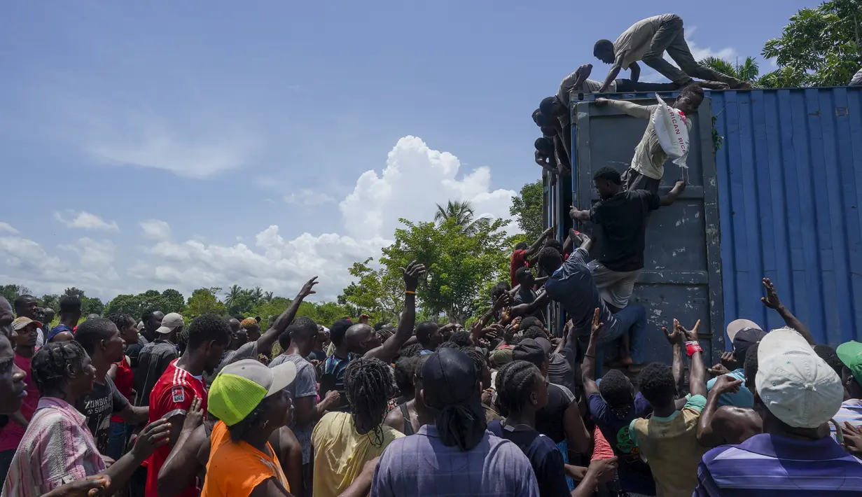 Warga naik ke truk yang penuh dengan pasokan bantuan untuk korban gempa, di Vey Terre, Haiti, Jumat (20/8/2021). Bantuan swasta dan kiriman dari pemerintah AS dan lainnya tiba di semenanjung barat daya negara itu yang dilanda gempa 7,2 gempa berkekuatan 14 Agustus. (AP Photo/Fernando Llano)