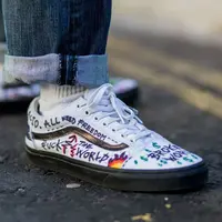 Kreatif sneakers putih dihiasi tulisan-tulisan.