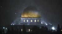 Salju turun di atas Masjid Kubah Batu, Kompleks Masjid Al-Aqsa, Kota Tua Yerusalem, 26 Januari 2022. Hujan salju yang jarang melanda sebagian wilayah Israel dan Tepi Barat telah menutup sekolah dan bisnis. (AP Photo/Mahmoud Illean)