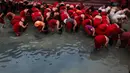 Sejumlah wanita Hindu melakukan mandi suci dI sungai Bagmati pada festival keagamaan Madhav Narayan, Nepal, Selasa (16/1). Dalam upacara ini mereka juga membaca kitab suci yang dipersembahkan untuk dewi Hindu Swasthani. (AP/Niranjan Shrestha)