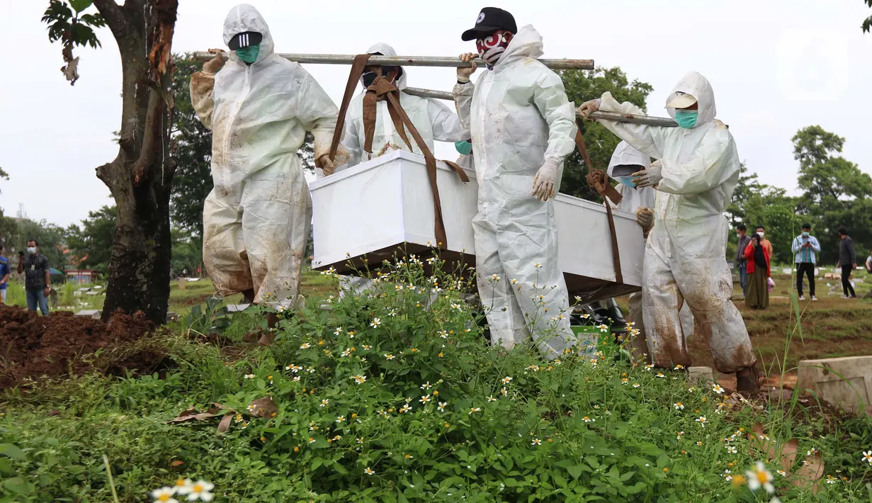 Petugas membawa peti berisi jenazah dengan protokol COVID-19 di TPU Srengseng Sawah, Jakarta, Kamis (21/1/2021). Sebagian lahan TPU Srengseng Sawah yang dijadikan lokasi pemakaman jenazah Covid-19 sejak Selasa (12/1) lalu, kini hanya tersisa 79 petak makam. (Liputan6.com/Helmi Fithriansyah)
