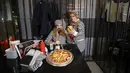 Wanita Iran mengenakan pakaian tahanan saat mereka makan di restoran berkonsep penjara "Sel 16" di Teheran, 4 Februari 2022. Sebagian dari hasil bisnis digunakan untuk membebaskan mereka yang mendekam di penjara Iran karena utang yang belum dibayar. (ATTA KENARE/AFP)