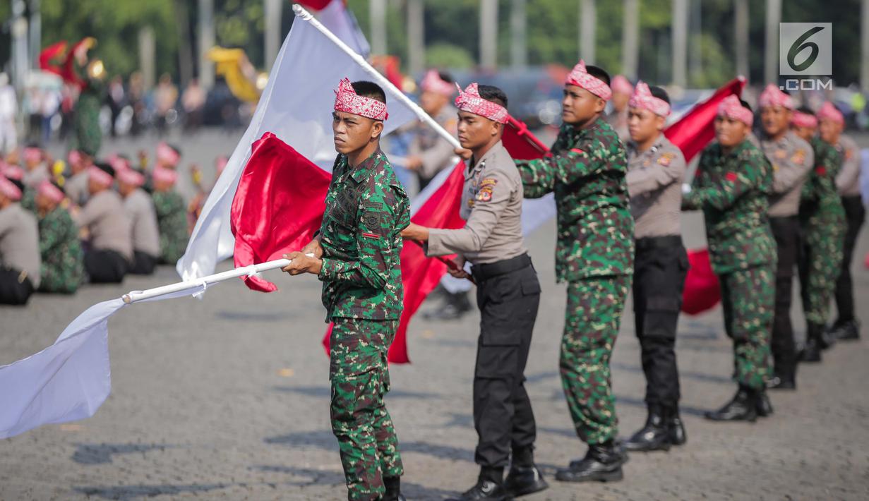 Prajurit TNI dan Polri berkolaborasi memainkan rampak gendang dalam HUT ke-73 Bhayangkara di Monas, Jakarta, Rabu (10/7/2019). HUT Bhayangkara ke-73 ini bertemakan ‘Dengan semangat Promoter, pengabdian Polri, untuk masyarakat, bangsa, dan negara. (Liputan6.com/Faizal Fanani)
