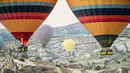 Sejumlah wisatawan terbang menaiki balon udara panas di atas Nevsehir di wilayah Cappadocia, Turki (5/9). Balon udara panas yang terbang di atas Cappadocia juga menjadi pemandangan menarik bagi para wisatawan. (AFP Photo/Yasin Akgul)