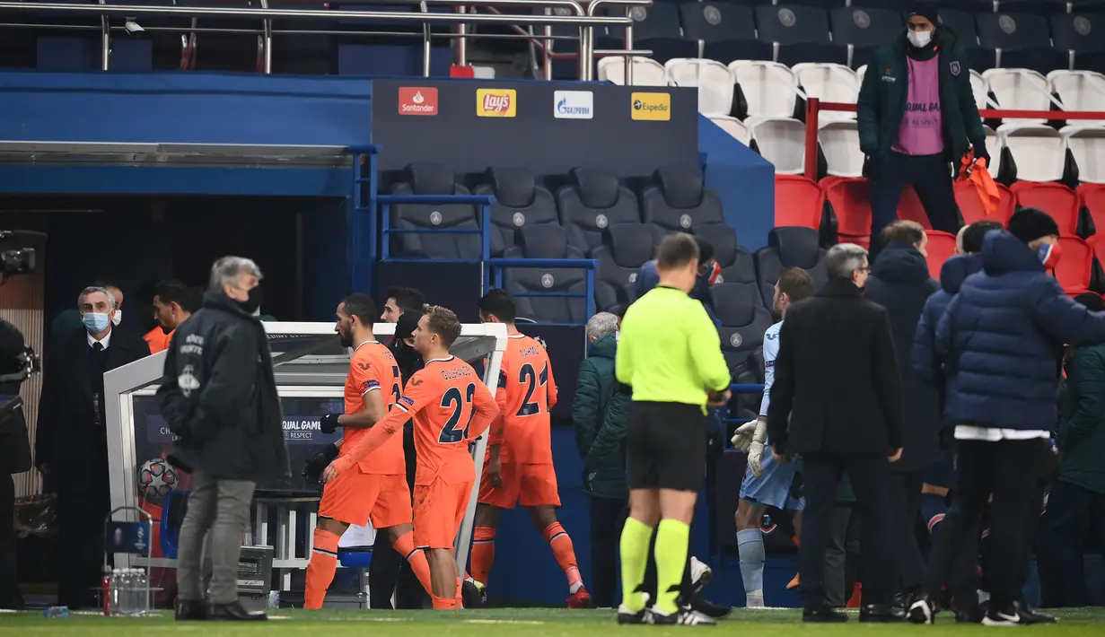 Para pemain Istanbul Basaksehir meninggalkan lapangan usai dihentikannya laga lanjutan Liga Champions Grup H melawan Paris Saint-Germain di Parc des Princes Stadium, Selasa (8/12/2020). (AFP/Franck Fife)
