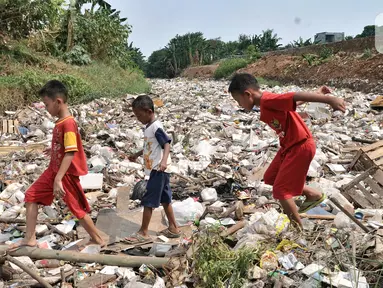 Anak-anak bermain di atas tumpukan sampah yang memenuhi Kali Jambe, Desa Satria Jaya, Tambun Utara, Bekasi, Jawa Barat, Kamis (31/10/2019). Sudah empat hari ini sampah sepanjang 200 meter memenuhi aliran Kali Jambe di Desa Satria Jaya. (merdeka.com/Iqbal Nugroho)