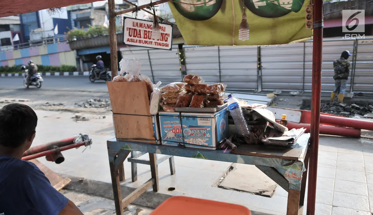 Pedagang lemang dan makanan ringan khas Sumbar berjualan di tengah proyek trotoar Jalan Kramat Raya, Jakarta, Senin (16/9/2019). Namun, dari sekitar 20 pedagang, hanya 6 kios yang masih berjualan karena tempat relokasi sementara tidak cukup menampung seluruh pedagang. (merdeka.com/Iqbal S. Nugroho)