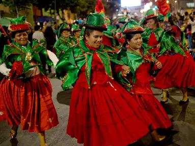 Sejumlah wanita mengenakan kostum elf menari saat parade Natal tahunan di La Paz, Bolivia (24/11). Pawai ini diselenggarakan oleh pedagang Pekan Raya Natal tahunan. (AP Photo/Juan Karita)