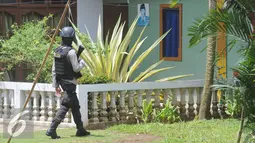 Petugas Kepolisian Brimob berjaga disekitar area rumah terduga teroris di Setu, Tangerang Selatan, Rabu (21/12). Setelah AN diinterogasi tim mendapatkan informasi bahwa bom akan diledakkan pada akhir tahun. (Liputan6.com/Helmi Affandi)