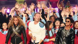 Beyonce, Chris Martin dari Coldplay dan Bruno Mars tampil pada halftime show Super Bowl 50 yang dihelat di Levi’s Stadium di Santa Clara, California, membuat semangat penonton pertandingan semakin membara, Minggu (7/2). (Christopher Polk/Getty Images/AFP)