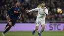 Gelandang Real Madrid, Marco Asensio, berebut bola dengan gelandang Valencia, Daniel Parejo, pada laga La Liga di Stadion Santiago Bernabeu, Madrid, Sabtu (1/12). Madrid menang 2-0 atas Valencia. (AFP/Oscar Del Pozo)