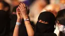 Seorang wanita yang telah divaksinasi virus corona bertepuk tangan saat menonton penyanyi Saudi Mohammed Abdu di Super Dome di Jeddah, Arab Saudi (8/7/2021). Konser ini diselenggarakan Otoritas Hiburan Umum Saudi. (AP Photo/Amr Nabil)