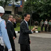 Presiden Joko Widodo terlihat tersenyum saat tiba di Bandara Halim Perdanakusuma usai menghadiri rangkaian KTT Asean ke-26 di Malaysia, Jakarta, Senin (27/4/2015). (Liputan6.com/Faizal Fanani)