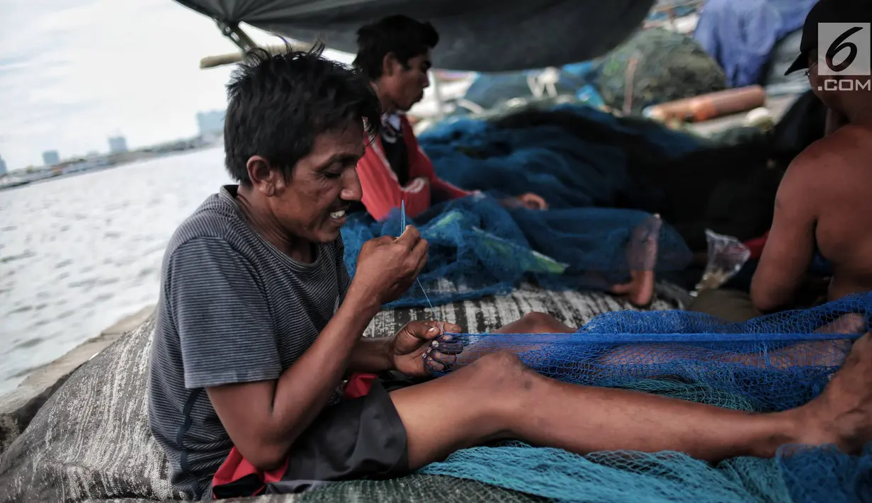 Sejumlah nelayan memperbaiki jaring di Pelabuhan Muara Angke, Jakarta, Kamis (27/12). Libur melaut dimanfaatkan nelayan untuk memperbaiki kapal dan jaring. (Liputan6.com/Faizal Fanani)