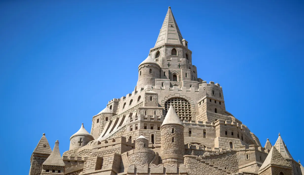 Sebuah istana pasir tertinggi pada kompetisi tahunan "Sand Sculptures Festival" di Binz, Pulau Reugen di Laut Baltik, Jerman pada 5 Juni 2019. Seekor naga dipahat di kaki dan dinding kastil persis seperti di serial film Game of Thrones. (Jens Büttner/dpa/AFP)