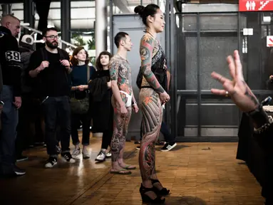 Dua model yang tubuhnya penuh tato berpose saat acara Konvensi Tattoo Paris (Mondial du Tatouage) di Grand Halle de la Villette di Paris (8/3). Acara ini telah berlangsung dari tanggal 9-11 April 2018. (AFP/Philippe Lopez)