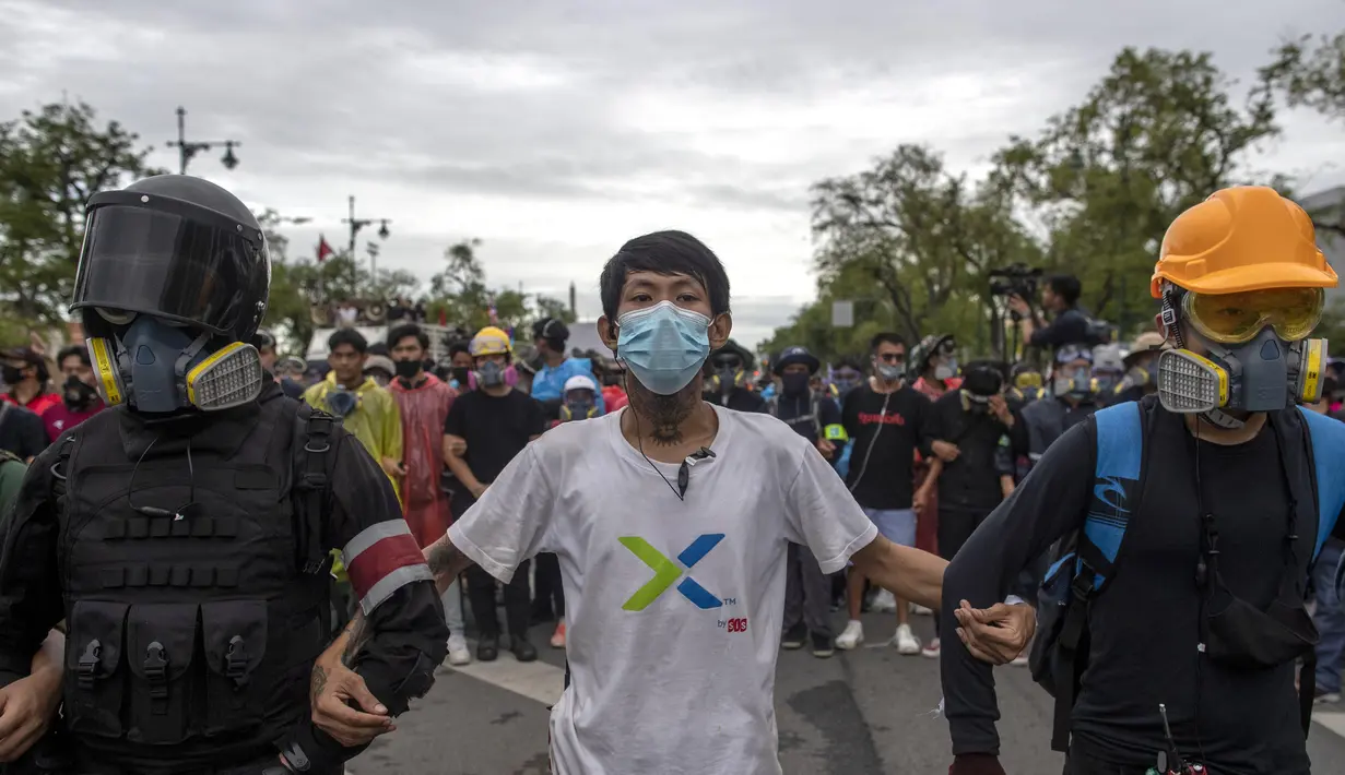 Pengunjuk rasa pro-demokrasi, beberapa dengan masker gas air mata pelindung membentuk rantai manusia selama pawai jalanan dekat Sanam Luang di Bangkok, Thailand, Minggu (20/9/2020). (AP Photo/Gemunu Amarasinghe)