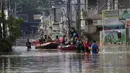 Warga duduk dalam perahu karet saat mereka mengungsi ke tempat yang lebih tinggi selama banjir di Bekasi, Jawa Barat, Kamis (17/2/2022). Hujan deras yang dikombinasikan dengan perencanaan pembuangan limbah kota yang buruk sering menyebabkan banjir besar. (AP Photo/Achmad Ibrahim)