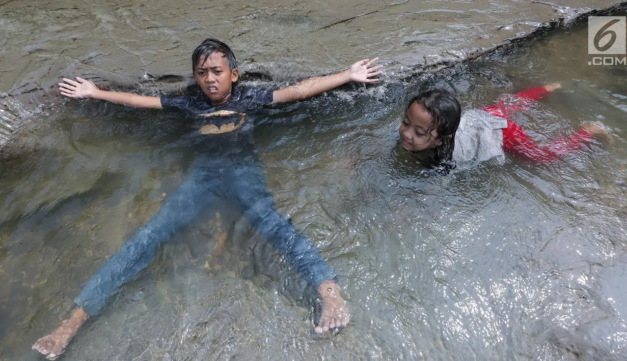 Anak-anak berendam di aliran sungai Gunung Sari, Desa Tajur, Pasirmukti, Citeureup, Bogor, Jawa Barat (24/6/2019). Liburan anak sekolah banyak dimanfaatkan bagi masyarakat disekitar Citeureup dan Cibinong untuk berwisata. (Kapanlagi.com/Budy Santoso)