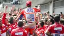 Gaya Andrea Dovizioso (tengah) merayakan kemenangan bersama tim usai balapan MotoGP Austria di Red Bull Ring, Spielberg, Austria (13/8/2017). Dovizioso menjadi juara stelah kalahkan Marquez pada lap terakhir. (AFP/Jure Makovec)