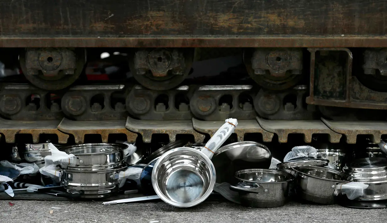 Sebuah alat berat dioperasikan untuk menghancurkan panci palsu dan peralatan dapur yang disita Badan Bea Cukai Swiss di Jenewa, Swiss, (16/6/2015). (REUTERS/Pierre Albouy)