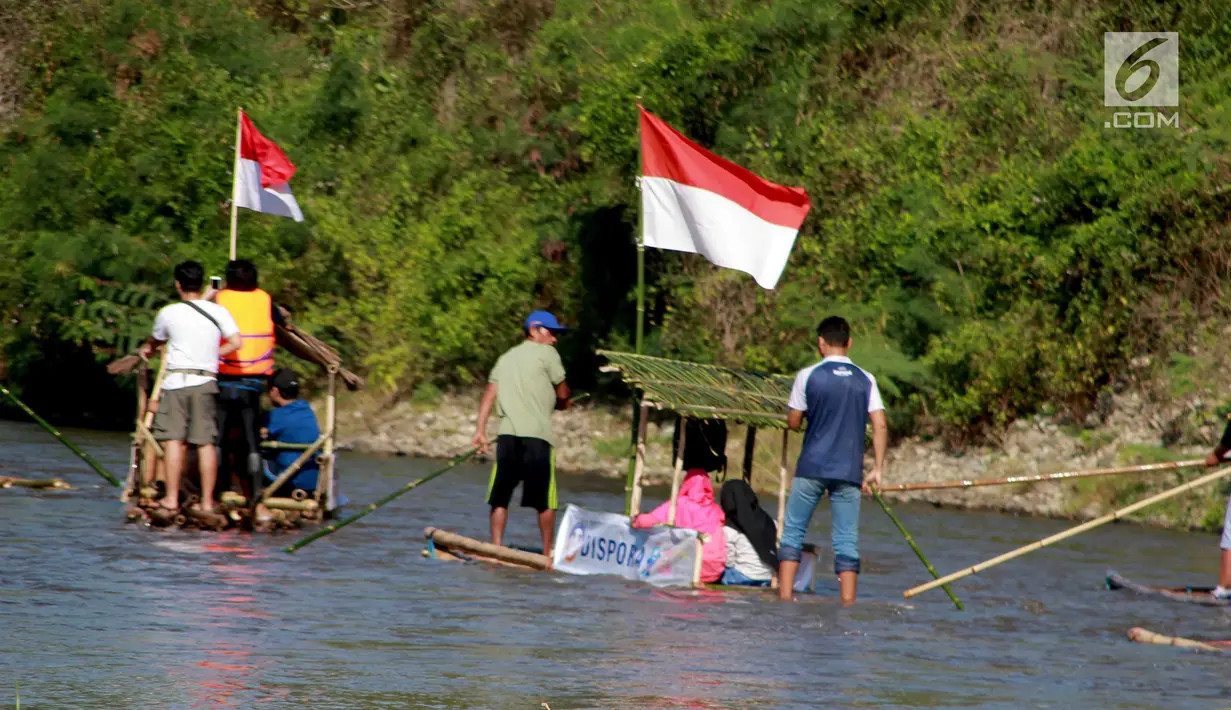 Peserta menyusuri sungai Bone menggunakan rakit tradisional di Gorontalo, Sabtu (23/3). Kegiatan ini dilaksanakan sebagai upaya meningkatkan kesadaran masyarakat Bonebol untuk bisa menjaga kelestarian sungai. (Liputan6.com/Arfandi Ibrahim)