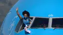 Lifter peraih medali emas, Neisi Patricia Dajomes Barrera melambaikan tangan dari ruang kokpit pesawat saat tiba di bandara Kota Equito, Ekuador, Rabu (4/8/2021). Neisi Patricia berhasil meraih medali emas usai berhasil juara angkat besi 76kg putri di Olimpiade Tokyo 2020. (AFP/Rodrigo Buendia)