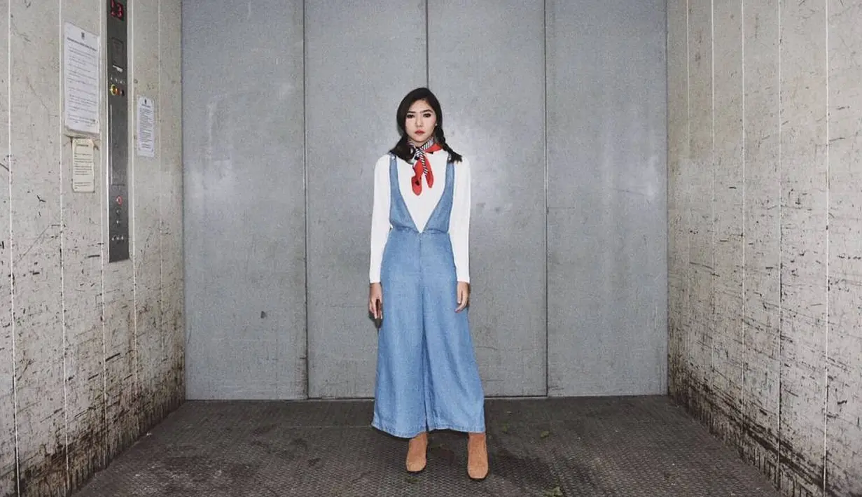 Gaya Isyana memang sangat kekinian baget. Seperti ini misalnya, Isyana memakai jumpsuit denim yang dipadukan dengan baju lengan panjang berwarna putih. Selain itu, ia juga  mengenakan scarf  di lehernya. Cantik banget ya? (Instagram/isyanasarasvati)