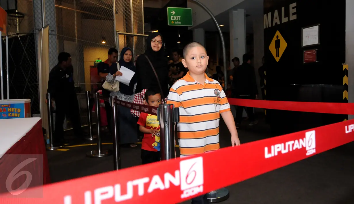 Salah satu anak terlihat ikut dalam antrian penonton yang akan menyaksikan film Minions di Bekasi Cyber Park, Minggu (28/6/2015). Film ini bergenre animasi yang dirilis Illumination Entertaiment. (Liputan6.com/Helmi Fithriansyah)