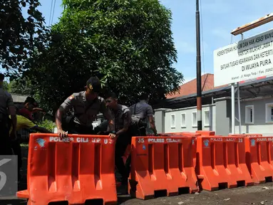 Sejumlah Polisi satuan Brimob memasang Water Barrier untuk  pengamanan menuju Dermaga Nusakambangan, Cilacap, Jawa Tengah, Rabu (27/7). Menjelang eksekusi Tahap 3 sejumlah persiapan dilakukan oleh Lapas Nusakambangan. (Liputan6.com/Helmi Afandi)
