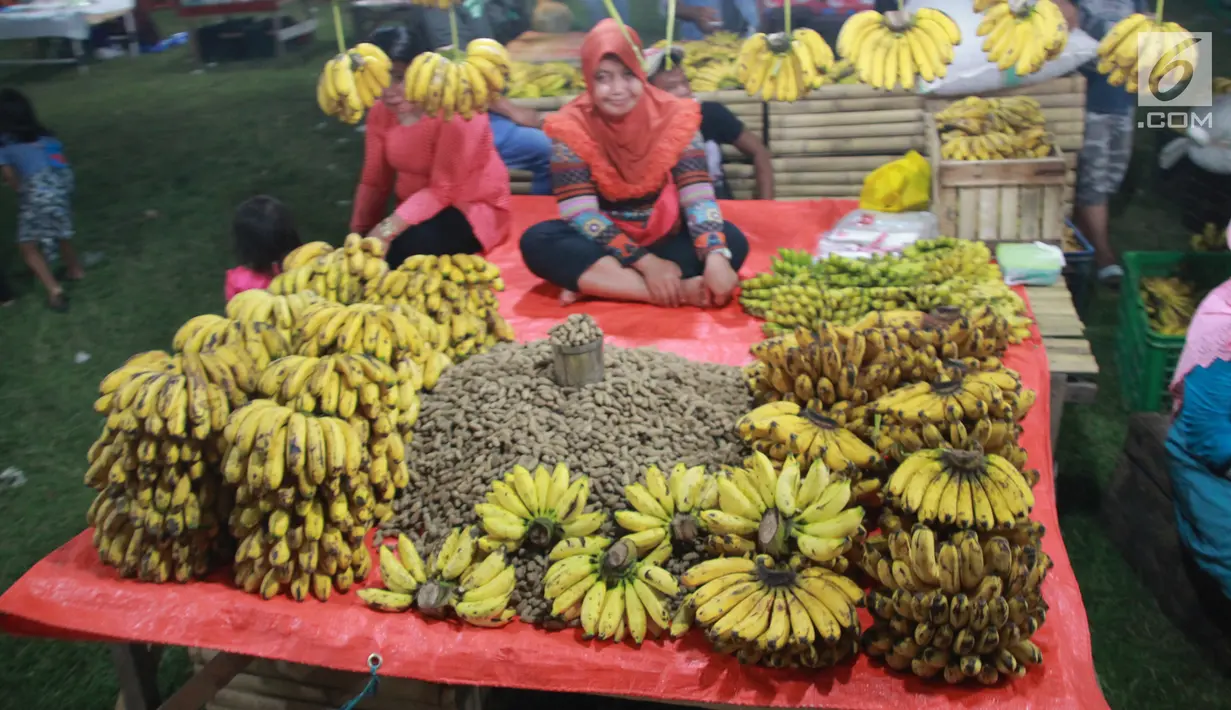 Pedagang menjual pisang dan kacang di pasar malam pada tradisi Malam Qunut di Desa Payunga, Kec. Batudaa, Kab. Gorontalo, Senin (20/5/2019). Tradisi Malam Qunut di Gorontalo dilakukan pada setiap pertengahan bulan Ramadan dengan beramai-ramai memakan pisang dan kacang. (Liputan6.com/Arfandi Ibrahim)