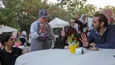 Seorang anak down syndrome Abdel Rahman melayani pelanggan di kedai kopi Sucet  selama festival "Sham gather us" di Damascus (11/7). Enam belas anak laki-laki dan perempuan down syndrome bekerja di Cafe Sucet melayani pelanggan. (AFP Photo/Louai Beshara)