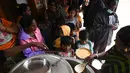 Otoritas sipil mendistribusikan makanan kepada penduduk di tempat penampungan sementara setelah hujan lebat di Chennai, India (8/11/2021). Hujan lebat terus menyebabkan genangan air di Chennai dan daerah sekitarnya. (AFP/Arun Sankar)