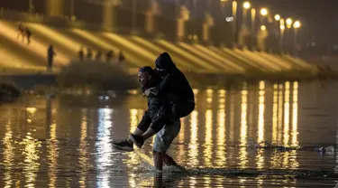 Migran bermalam di luar pagar perbatasan AS-Meksiko sambil menunggu pengajuan suaka di El Paso, Texas, di Ciudad Juarez, Meksiko, Rabu (21/12/2022).  Akibatnya Gubernur Texas Greg Abbott memerintahkan 400 tentara ke perbatasan AS-Meksiko di El Paso, yang berada dalam keadaan darurat karena gelombang migran yang menyeberang dari Meksiko ke kota. (JOHN MOORE / GETTY IMAGES NORTH AMERICA / Getty Images via AFP)