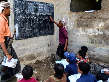 Seorang guru mengajar anak-anak dalam kelas agama di tempat terbuka di luar gedung yang sudah rapuh yang menjadi sekolah darurat di Mokha, provinsi barat Yaman, Taiz, pada 27 Agustus 2024. (Khaled ZIAD/AFP)