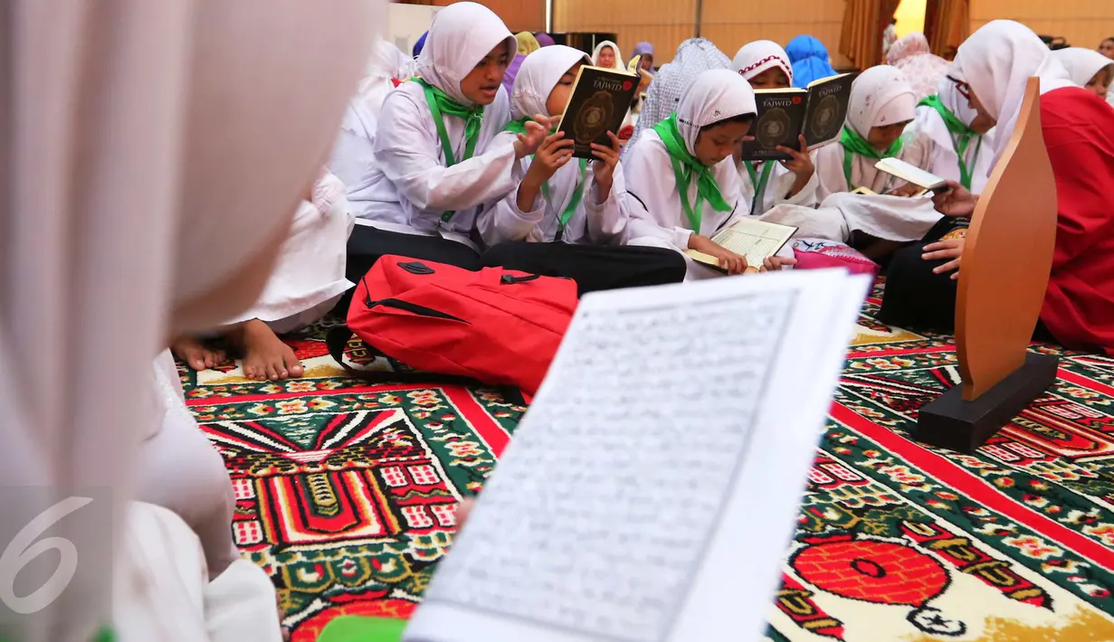 Sejumlah santri membaca ayat suci Al Quran di Gedung Pertamina, Jakarta, Kamis (23/6). Dalam rangka peringatan Nuzulul Quran, Pertamina bersama 27.218 anak yatim se-Jakarta membaca kitab suci Al Quran hingga khatam. (Liputan6.com/Angga Yuniar)