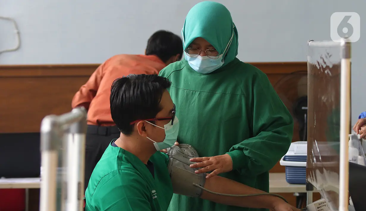 Seorang tenaga medis  menjalani penapisan kesehatan sebelum disuntik vaksin CoronaVac dari SinoVac di Rumah Sakit JatiSampurna, Bekasi, Jawa Barat, Kamis (28/01/2021). RS JatiSampurna melakukan Penyuntikan dosis kedua vaksin COVID-19.  (Liputan6.com/Herman Zakharia)