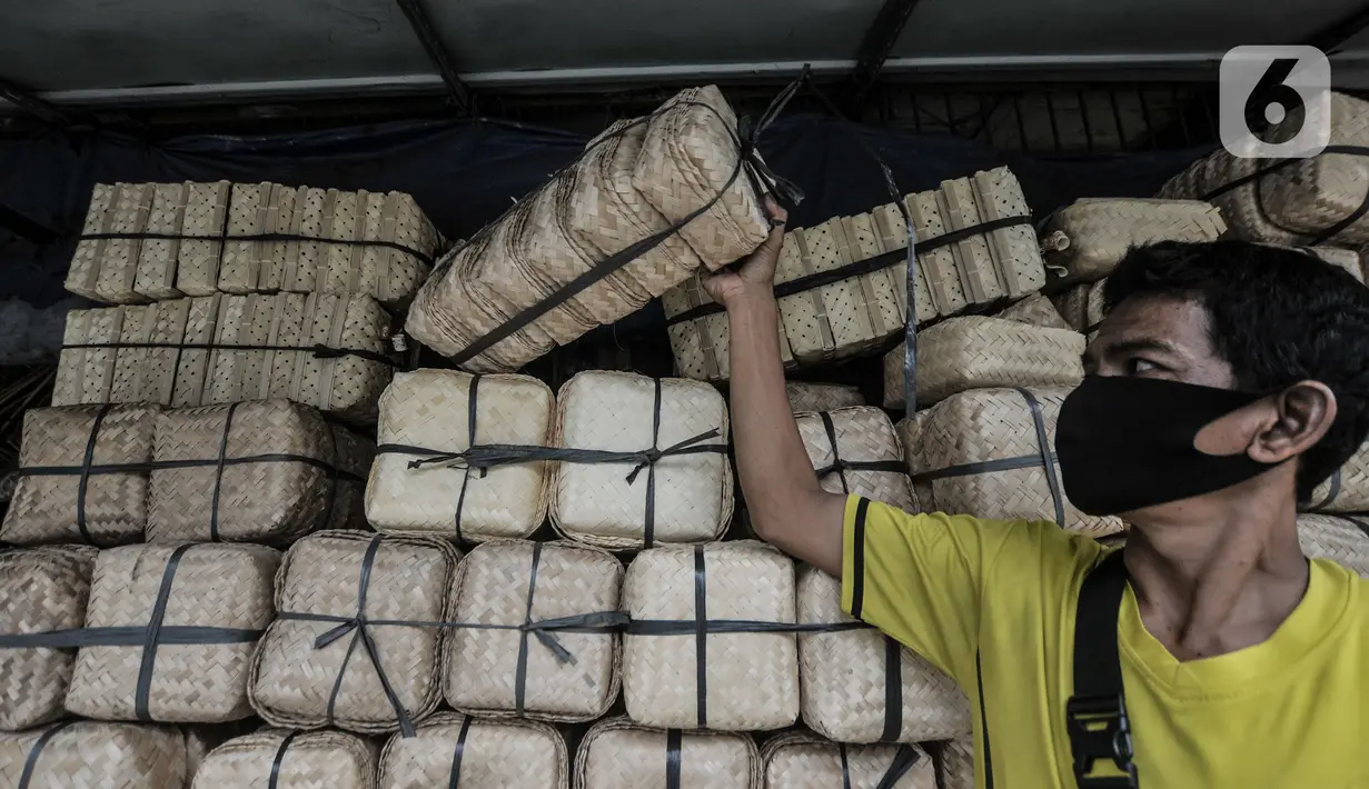 Pedagang mengambil besek bambu di kawasan Jatinegara, Jakarta, Senin (19/7/2021). Penjualan besek bambu yang digunakan sebagai wadah daging kurban saat Idul Adha pada tahun ini mengalami penurunan hingga 50 persen. (merdeka.com/Iqbal S. Nugroho)