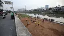 Sejumlah anak bermain sepak bola di sebuah lahan kosong di Pinggir Banjir Kanal Barat, Jakarta, Selasa (12/10/2021). Alih fungsi lahan menjadi kawasan hunian dan perkantoran mengakibatkan semakin minimnya lahan bermain bola bagi anak di Ibu kota.  (Liputan6.com/Johan Tallo)